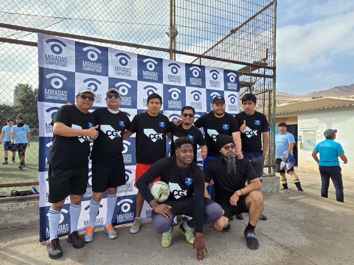 Equipo de CGK posando frente al telón de la Fundación Miradas Compartidas en la cancha